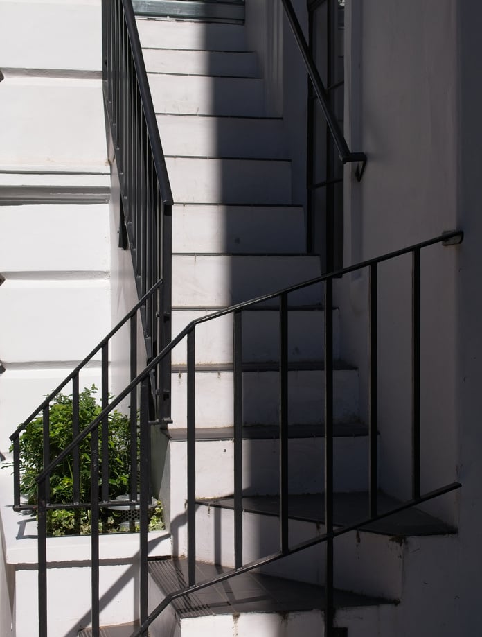 White staircase with black iron handrails.